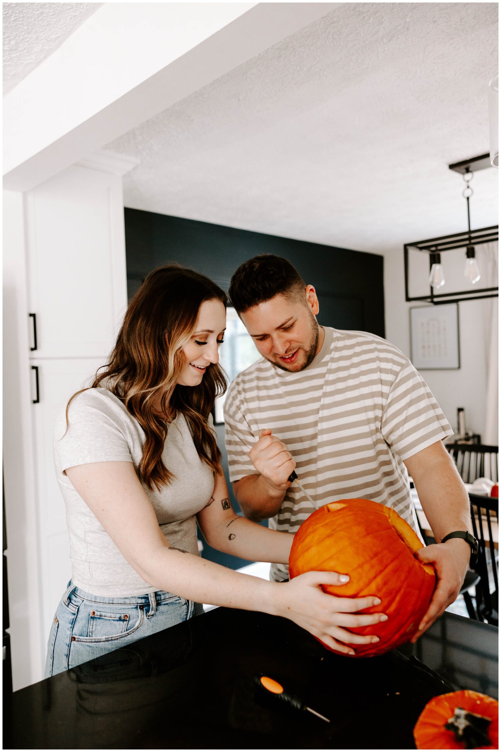 carving a jack-o-lantern for engagement photos