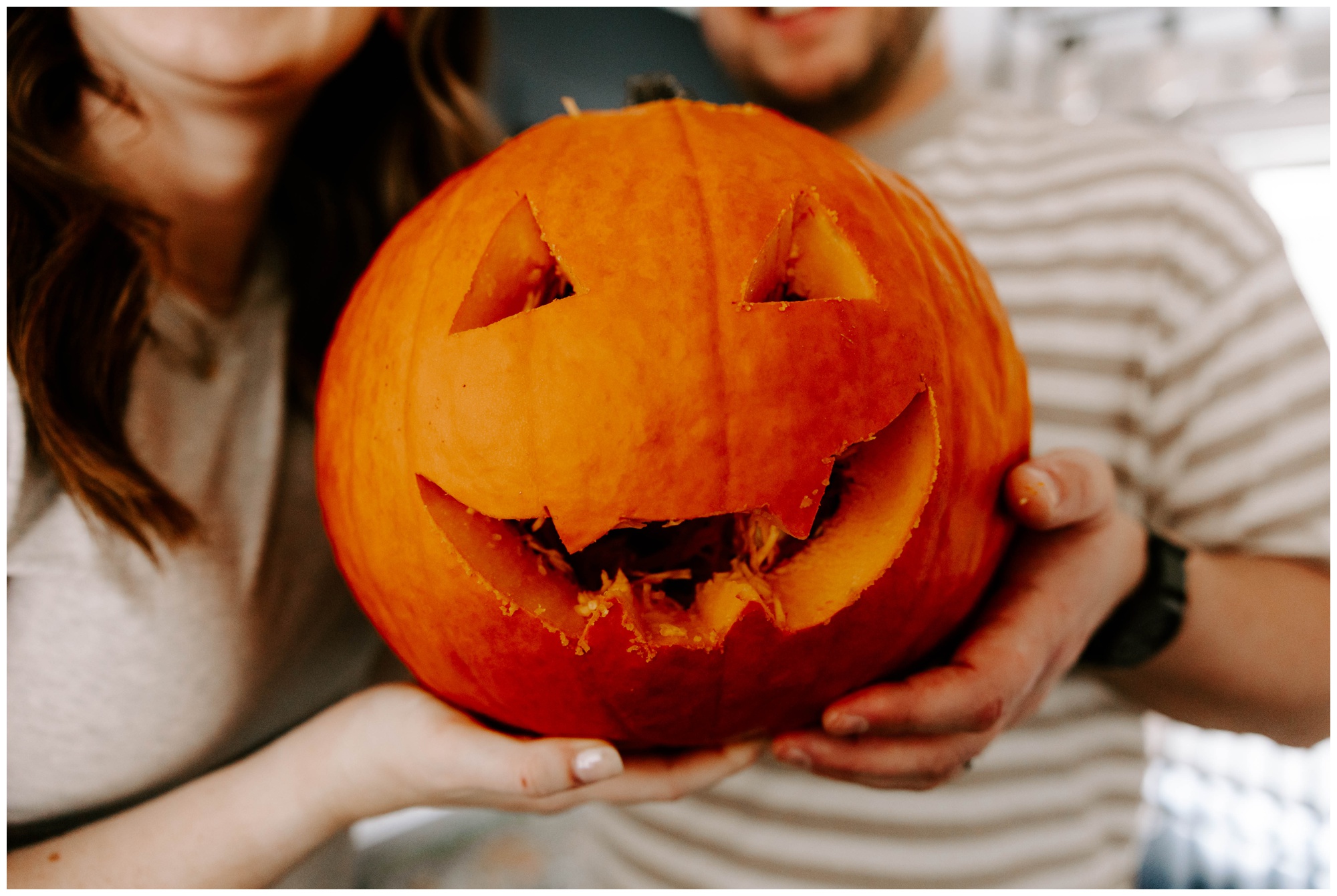 carving a jack-o-lantern for engagement photos