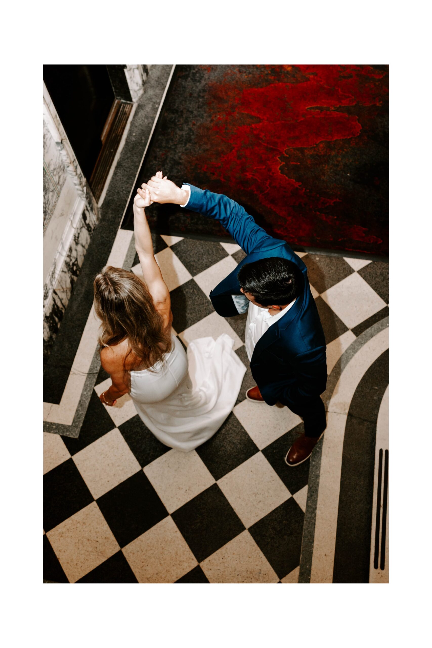 Couple posing in historic Beaux Arts hotel with marble and mosaic details