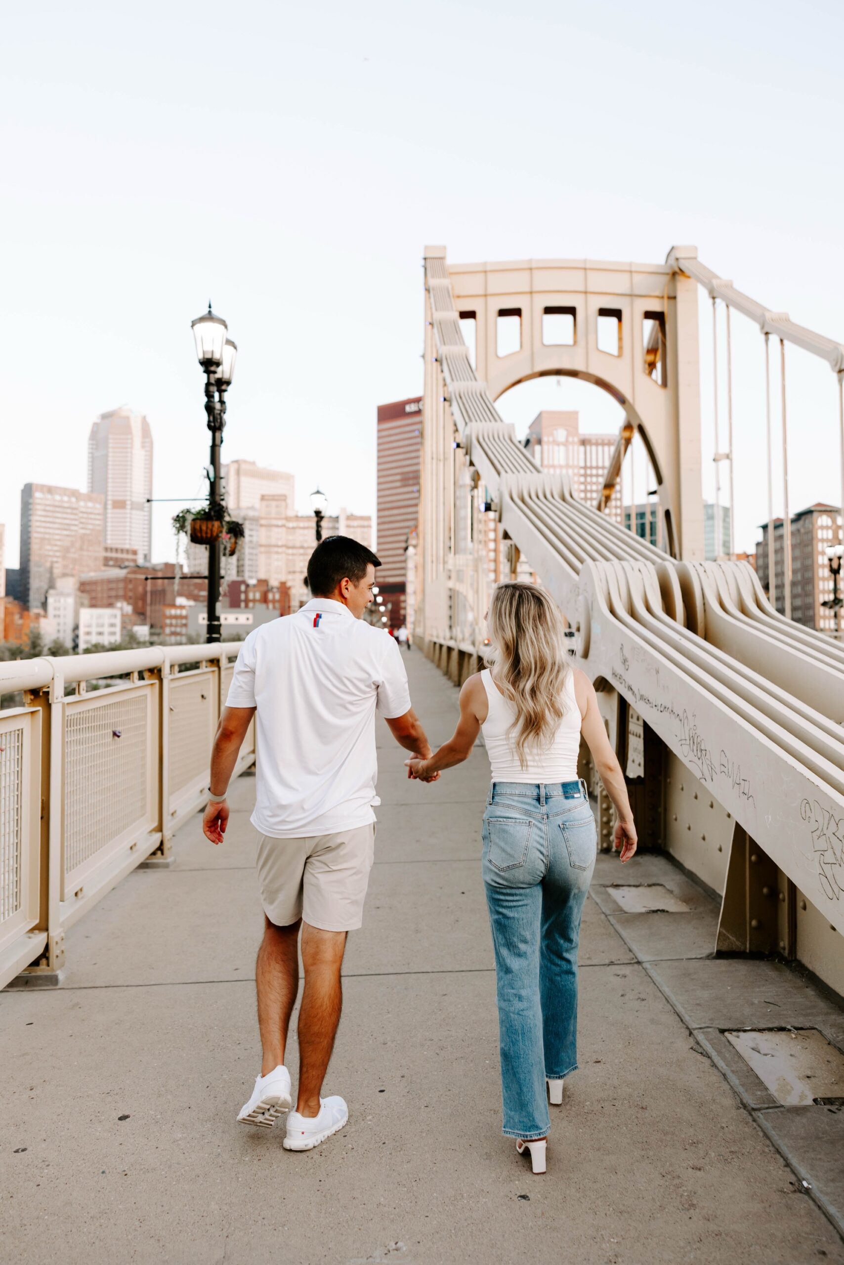 Joyful candid moment of engaged couple walking on bridge