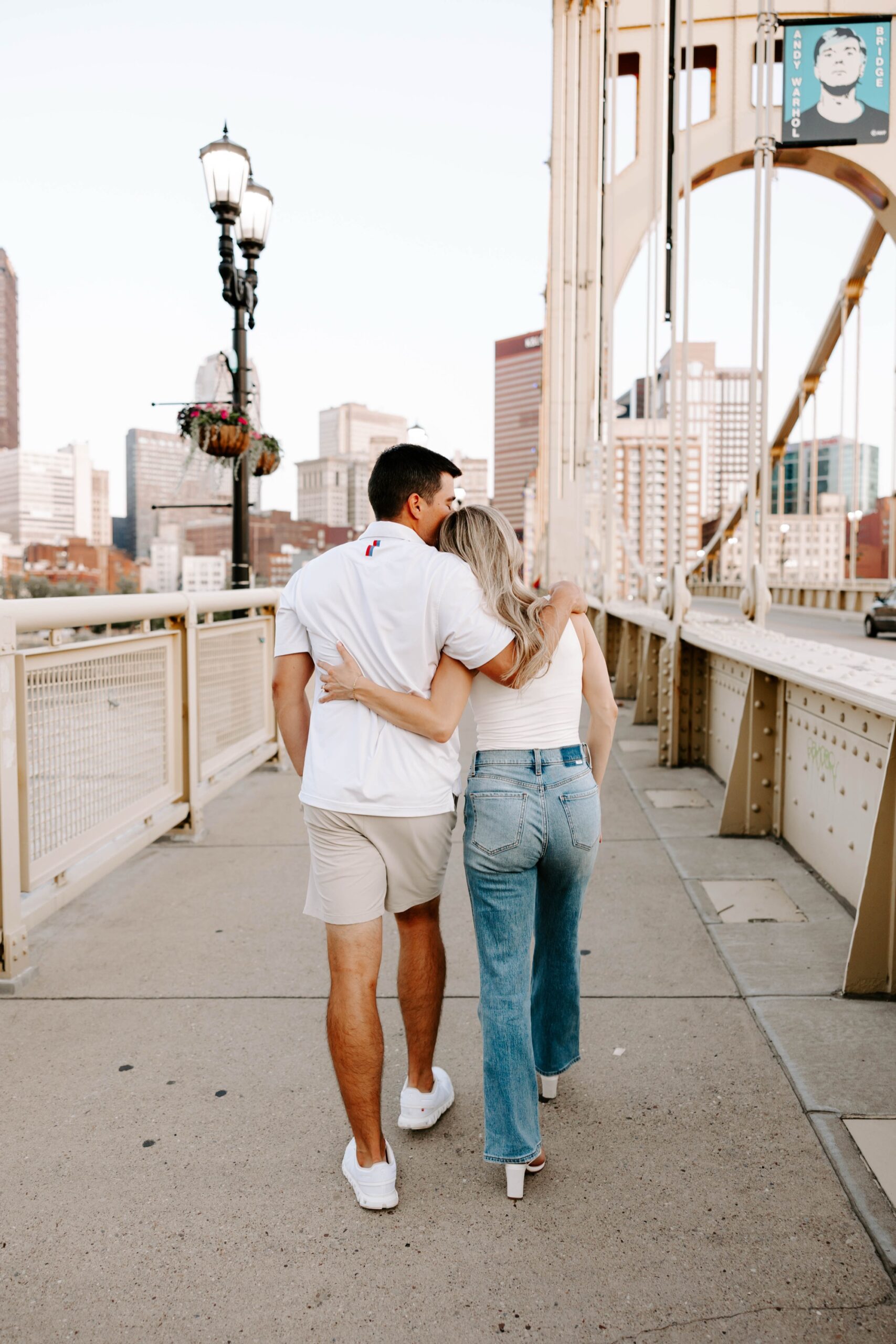 Joyful candid moment of engaged couple walking on bridge