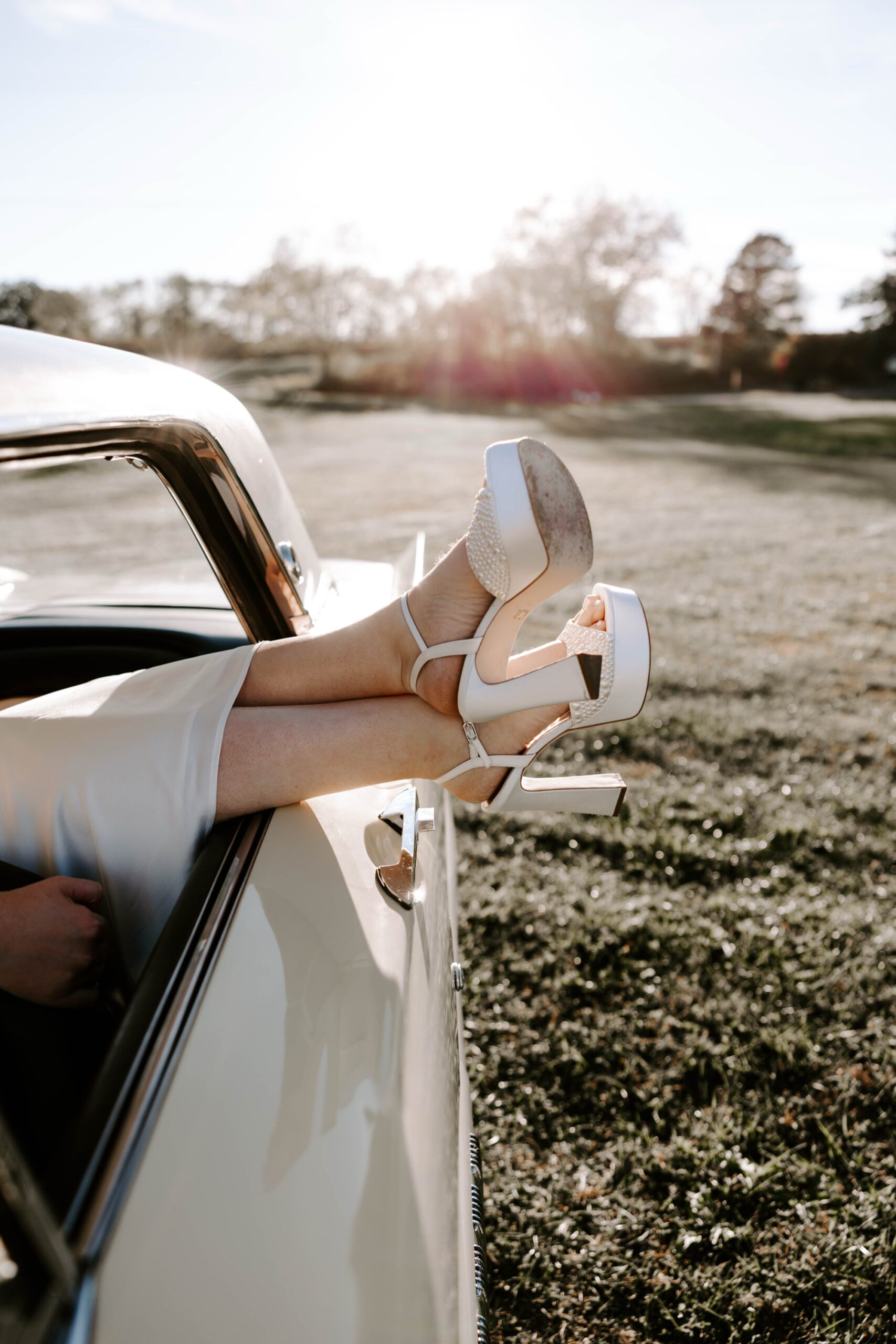 Creative save-the-date photo with couple posing beside vintage ca