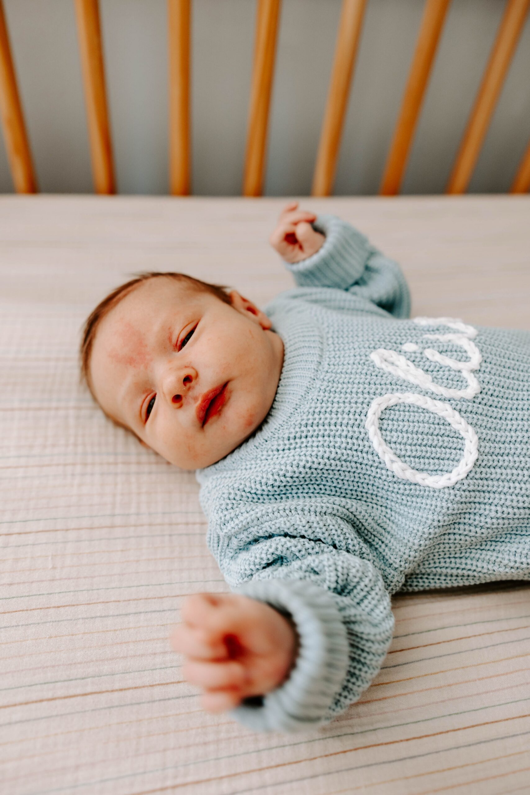 lifestyle newborn photography; personalized newborn knit name onesie sweater